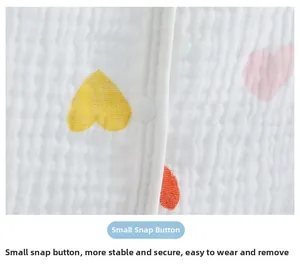 Detail of soft cotton muslin nursing shawl featuring small resin snap buttons and heart print