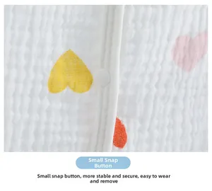 Detail of white cotton gauze shoulder wrap featuring heart print and secure snap button