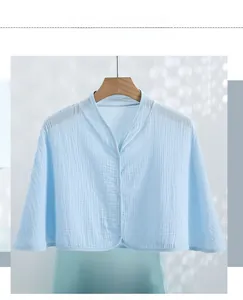 Close-up of light blue cotton crepe shawl featuring snap buttons and fine edging