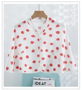 Detailed close-up of white cotton gauze shawl with strawberry pattern and V-neckline edge