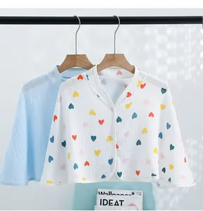 Detail view of cotton gauze nursing capes in solid blue and heart print for shoulder warmth
