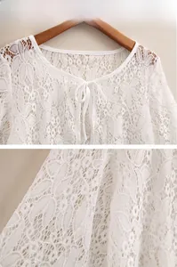 Detailed close-up of white floral lace texture and bow tie neckline on the sun shawl