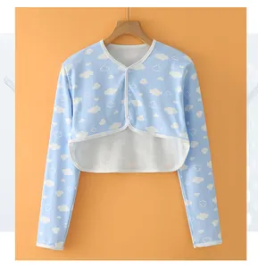 Macro detail of breathable cotton baby shrug with white cloud pattern and buttons