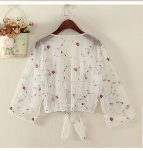 Detailed embroidery view on white mesh sun protection shawl with purple floral patterns