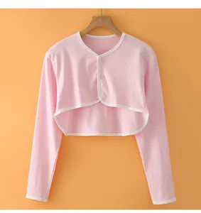 Detailed view of pink cotton shoulder wrap with white piping and two transparent buttons