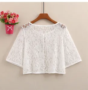 Detail of white floral lace cardigan showing delicate mesh texture and wide sleeves