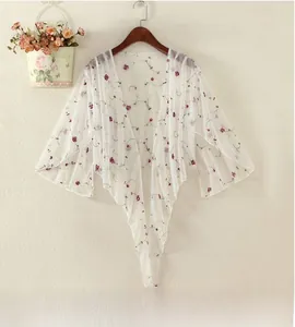 Close-up of translucent white mesh cardigan featuring delicate purple floral embroidery