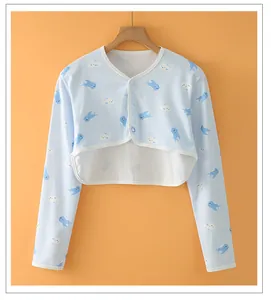 Close-up of baby cotton cardigan with blue shark prints on warm orange background