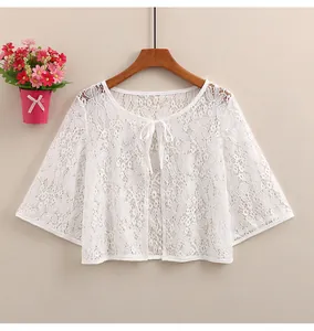 Close-up of delicate floral lace pattern on white summer cardigan with flared sleeves