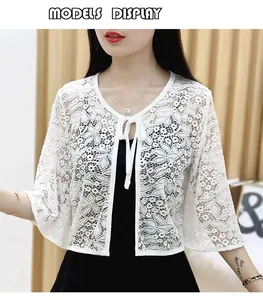 Close-up of white floral lace cardigan with bell sleeves and delicate tie-front detail