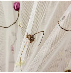 Close-up of the delicate floral embroidery on white sheer mesh summer sun protection fabric