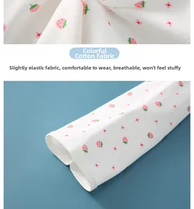 Detail of soft breathable cotton fabric with red strawberry and pink flower patterns