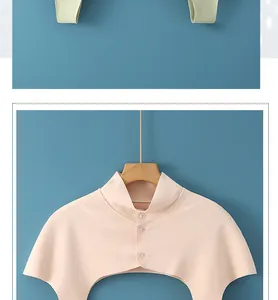 Détail du chauffe-épaule en tricot rose avec fermeture à boutons pour protéger le cou