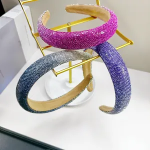 Glinsterende brede strass-hoofdbanden in magenta, paars en grijs op gouden standaard