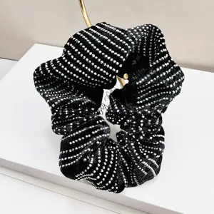 Détail d'un chouchou vintage français en velours noir avec des rayures élégantes en strass