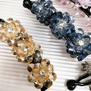 Gros plan de pinces banane fleurs en cristal de luxe en bleu, champagne, rose et noir