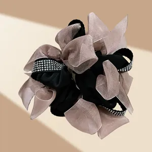 Detailed view of champagne organza bows and silver rhinestones on a layered scrunchie