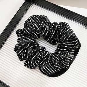 Detail of premium black velvet scrunchie with sparkling silver rhinestones and soft pleats