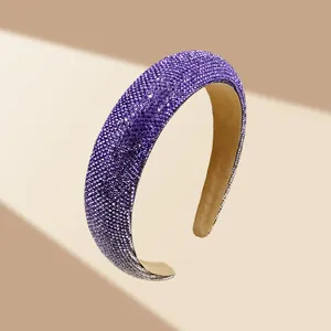 Detailweergave van de donkerpaarse gevoerde hoofdband met glinsterende strassteentjes