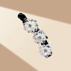 Détail macro des fleurs en cristal élégantes sur la pince banane noire pour femmes