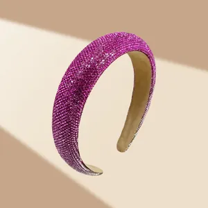 Detailweergave van de fuchsia gewatteerde haarband met glinsterende strass-steentjes