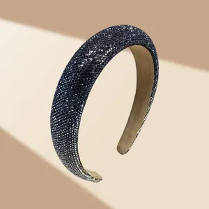 Detail van een gewatteerde hoofdband met blauwe strass-steentjes en fluwelen voering