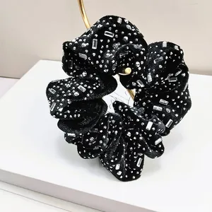 Detail of black velvet scrunchie with sparkling silver rhinestones and crystal accents