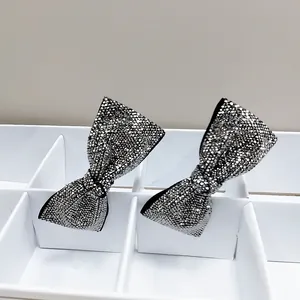 Macro detail of high-density silver rhinestones on sparkling bow hair clips for women