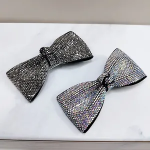 Macro detail of bow-shaped duckbill hair clips with sparkling rhinestones in two colors