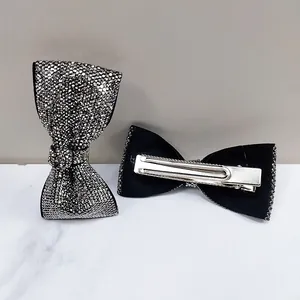 Detailed macro view of sparkling rhinestone bow hair clips with silver duckbill clasp