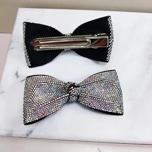 Macro detail of rhinestone bow hair clip showing sparkling stones and metal duckbill grip