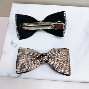 Detail of bow hair clips showing champagne rhinestone surface and metal spring buckle