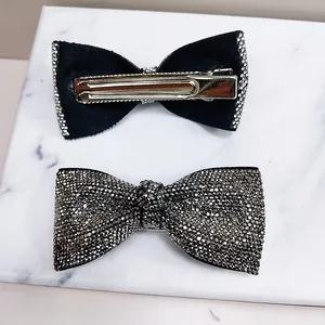 Detail view of bow hair clip featuring rhinestone inlay and a metal duckbill clip