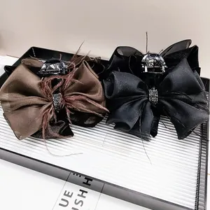 Elegant bow hair claw clips with feathers and crystals in black and brown shades