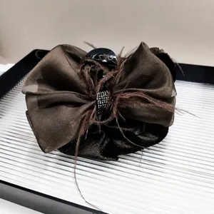 Detail of 13cm coffee brown tulle bow hair claw clip with feathers and rhinestones