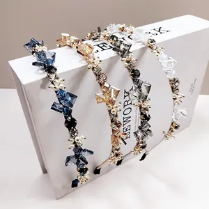 Serre-têtes élégants en cristal et perles en quatre couleurs sur un support blanc décoratif