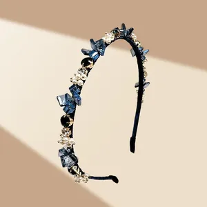 Détail d'un serre-tête de luxe orné de cristaux bleus et de perles blanches