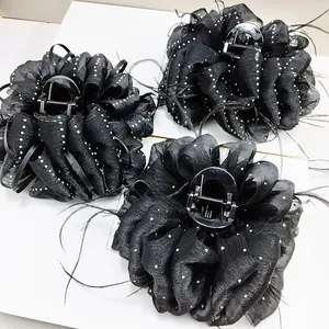 Macro detail of large black cloud feather hair claw clips with white polka dot patterns