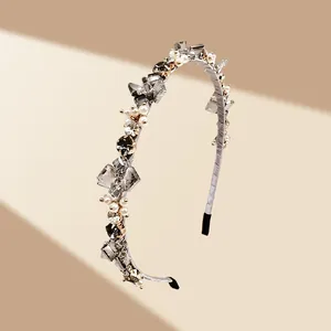 Détail d'un serre-tête élégant orné de cristaux et perles avec sertissage à la main