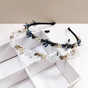 Serre-têtes élégants en cristal et perles blanc et bleu marine dans une boîte grillagée