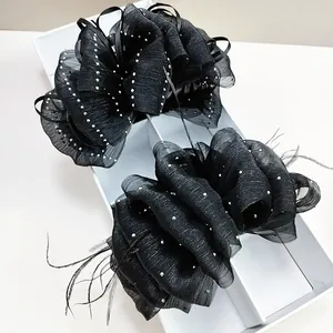 Detail of black cloud seersucker hair claw clip with rhinestones and feather trim