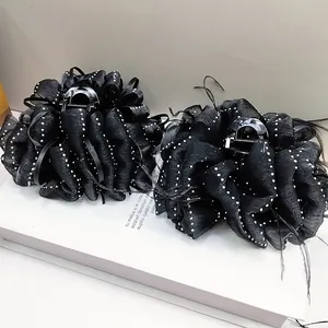 Elegant black bubble gauze hair claw with white polka dots and delicate feather accents