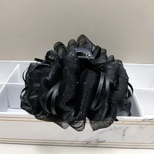 Detail of black cloud bubble gauze hair claw clip with delicate beaded accents on tray