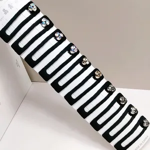 Close-up of ten black rectangle BB hair clips with shiny rhinestones on display card