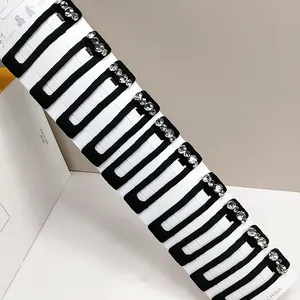 Detail of ten black velvet snap hair clips with sparkling rhinestones on a white card