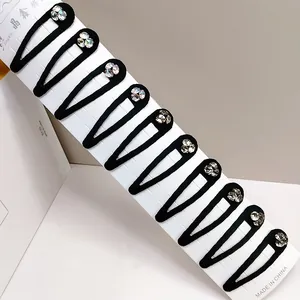 Detail of 10-piece black snap hair clips set with sparkling rhinestones and matte finish