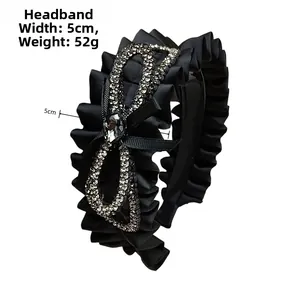 Detail of black pleated headband with oversized rhinestone bow, 5cm width and 52g weight
