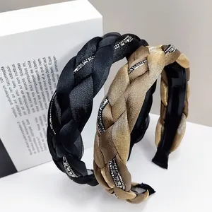 Detalle de diademas trenzadas en negro y dorado con cristales de strass brillantes