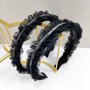 Détail de serre-têtes en maille plissée noire avec strass et dents antidérapantes