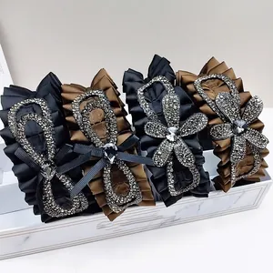 Detail of luxury rhinestone headbands with pleated satin fabric in a marble display box